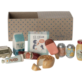 Miniature food items and packaging arranged in front of a cardboard box with a pattern.